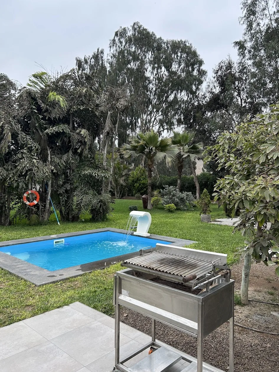 Piscina privada con cascada y zona BBQ del bungalow de Cinco Olivos